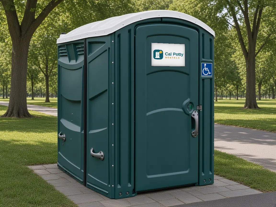 A teal ADA-accessible portable restroom with a wheelchair sign on a brick paved spot beside a park path, an example setup for porta potty rental in Santa Clara